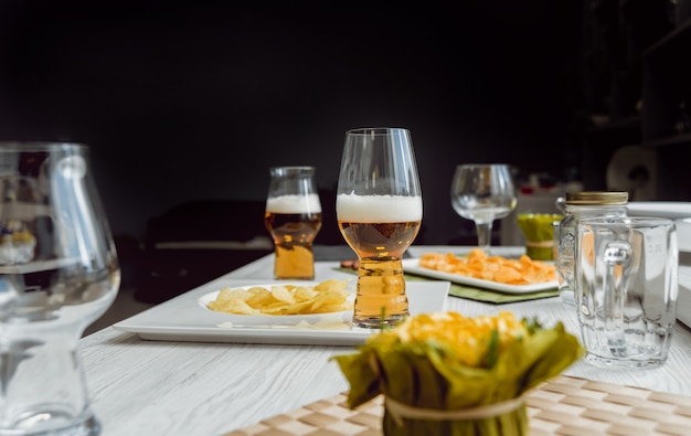 Beer and chips on a large white table