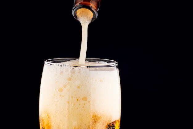 Beer in foam glass pour closeup