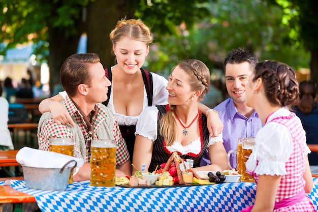 Photo in beer garden - friends on a table with beer