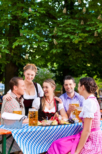 В пивном саду - друзья на столе с пивом