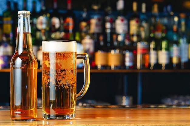 Beer glass and bottle on wooden countertop in a pub