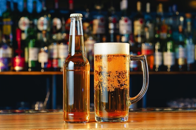 Beer glass and bottle on wooden countertop in a pub