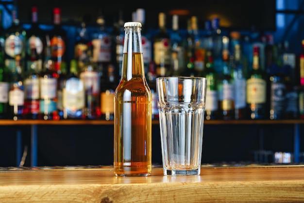 Beer glass and bottle on wooden countertop in a pub