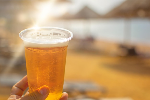 暑い日のビーチでのビールグラス、家族での休暇のコンセプト、紅海のアカバ・ヨルダンのエキゾチックなビーチ