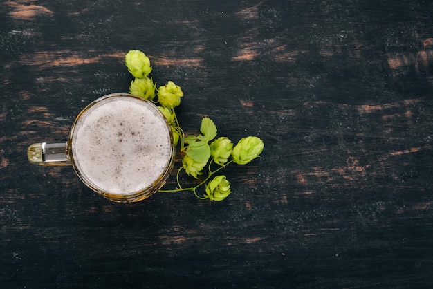 Foto birra in una tazza di vetro su un tavolo di legno nero spazio libero per il testo vista dall'alto