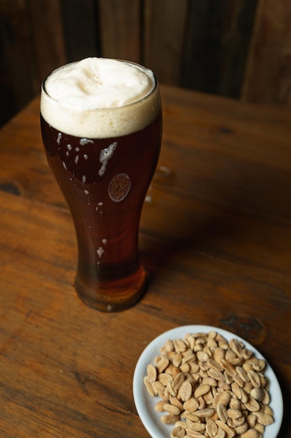 Beer glass and peanuts on a table