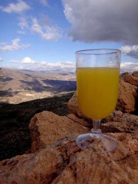 Foto un bicchiere di birra sulla roccia contro il cielo