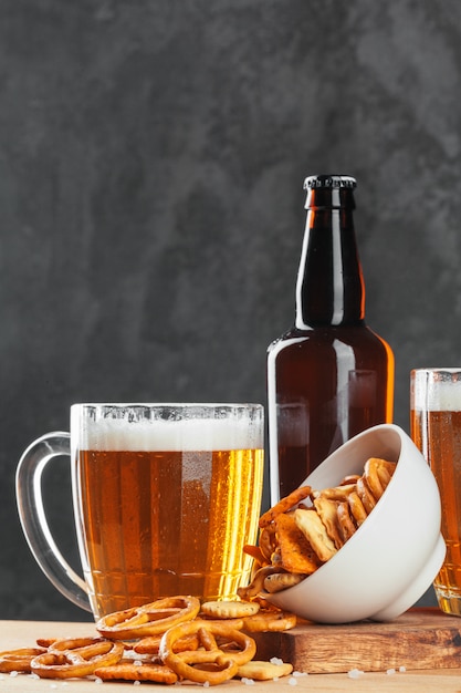 Beer glass with bretzel and dried sausages snacks close up