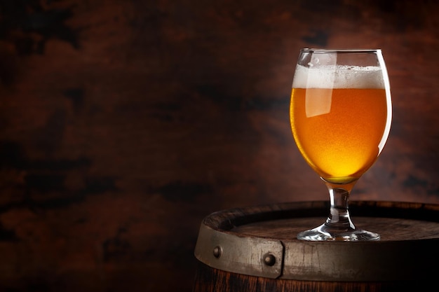 Beer glass on wooden barrel