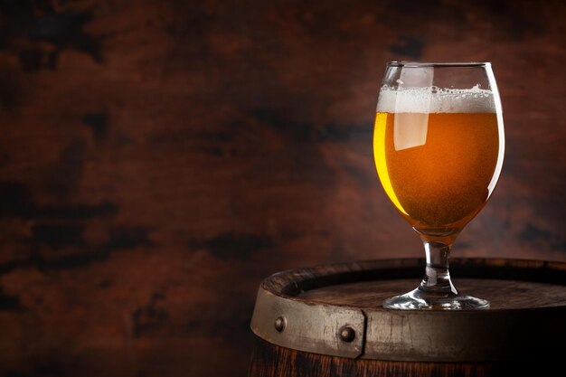 Beer glass on wooden barrel