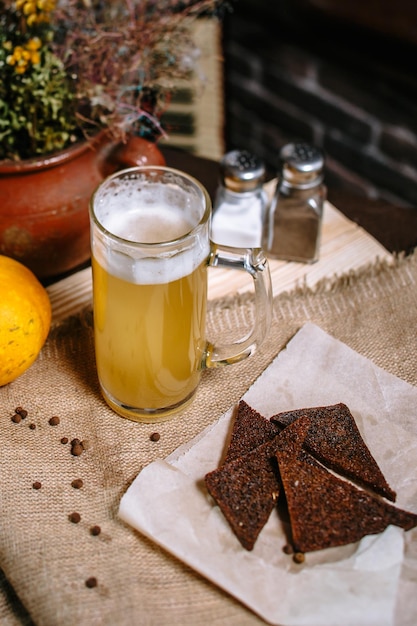 Beer in a large mug standing on the table Fried toast from black bread in a plate