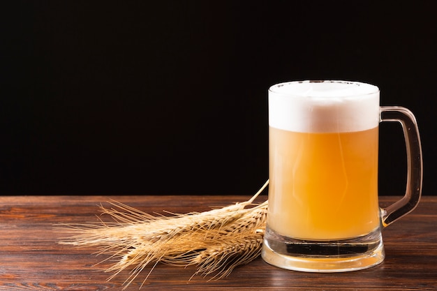 Boccale di birra e orzo sul bordo di legno