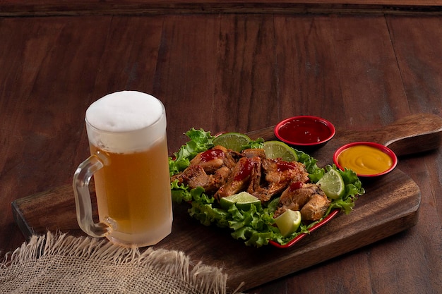 Beer mug on wooden board with portion of fried chicken