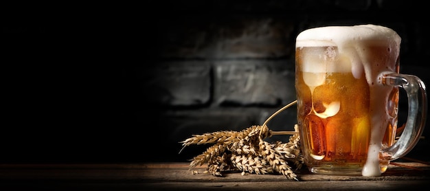 Beer in mug on wooden table near brick wall