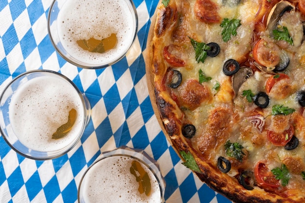 Birra e pizza sulla tovaglia bianca e blu oktoberfest