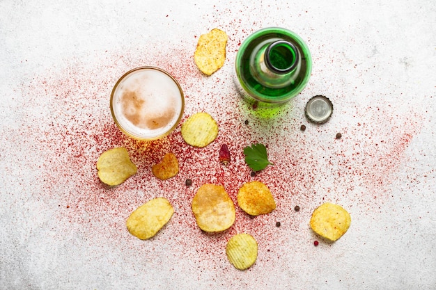 Beer and potato chips on a gray background.