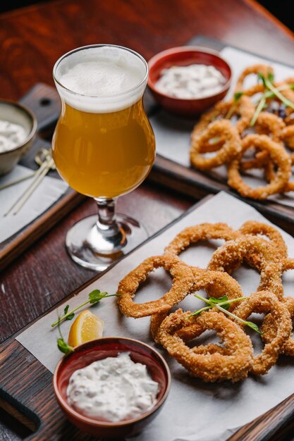 Beer set appetizers fried squid rings with tartar sauce and glass of beer