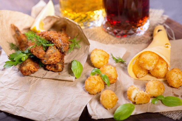 Beer snacks. Fried fried fish and cheese balls with lemon and greens. Snacks to different beers.