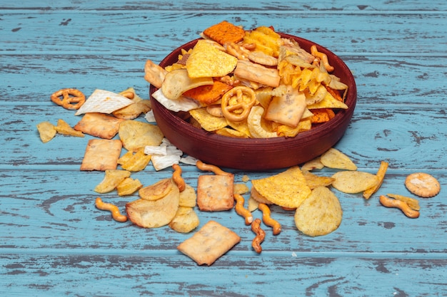 Beer snacks like crackers, chips, cookies on a wooden surface