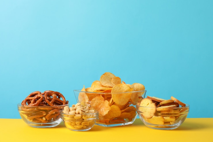Photo ビールスナック、ポテトチップス、ボウルにクラッカー、黄色に対して青、テキスト用のスペース
