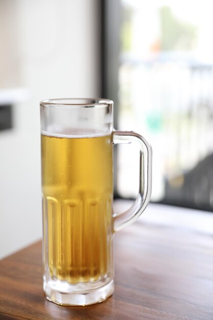 Beer in tall glass on wood background