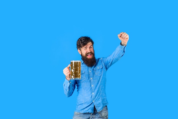 ビールタイムひげを生やした男は、ビアグラスのお祝いオクトーバーフェストフェスティバルを開催しますハンサムな男はでエールを飲みます