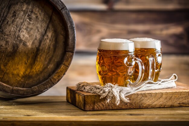 Beer. Two cold beers. Draft beer. Draft ale. Golden beer. Golden ale. Two gold beer with froth on top. Draft cold beer in glass jars in home pub hotel or restaurant. Still life.