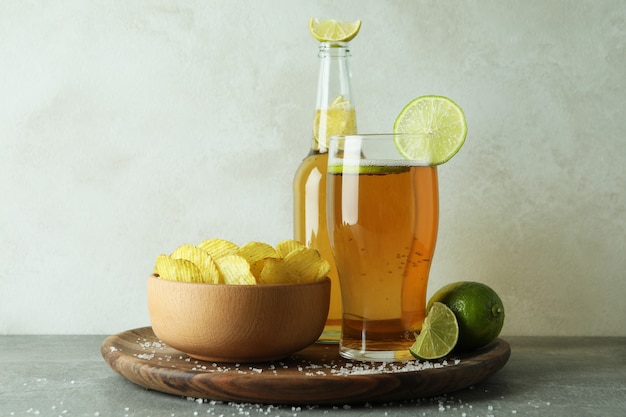 Beer with snacks against white textured background