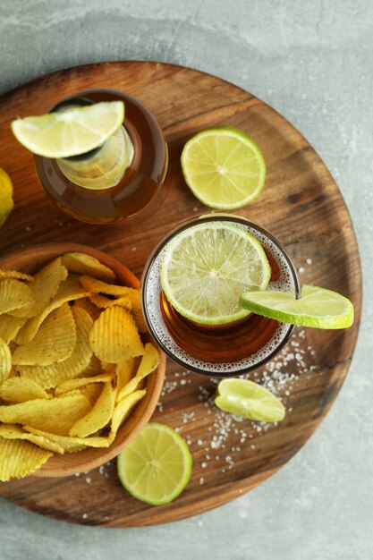 Beer with snacks on gray textured background