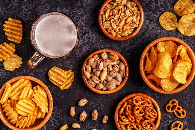 Beer with snacks on stone surface