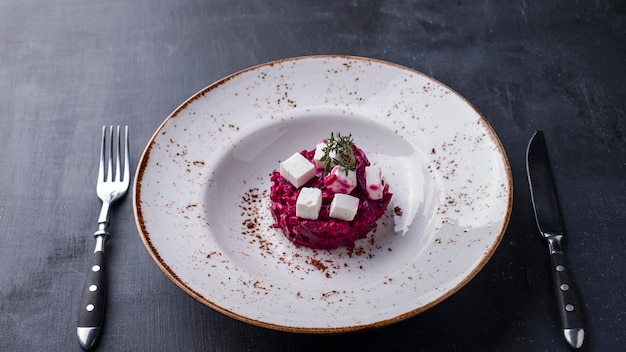 Beet salad on a plate served with fork and knife