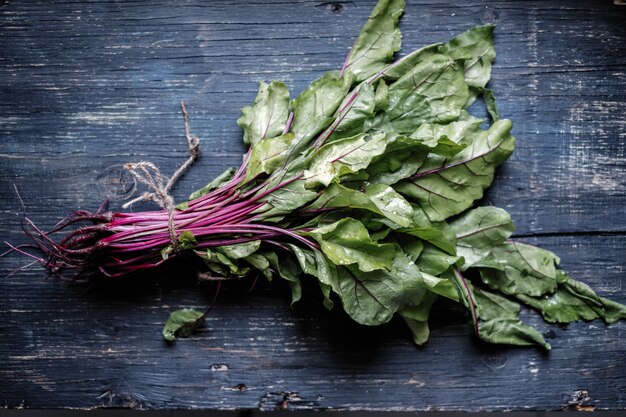 Beet with tops, with green leaves on dark