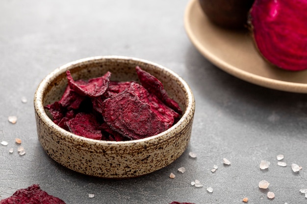 Beetroot chips in a bowl on a gray background Healthy vegetable chips snack for vegetarians