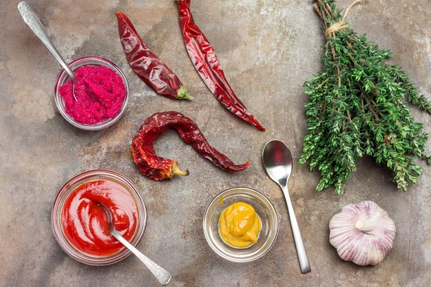 Beetroot horseradish and mustard, tomato sauce in glass bowls.