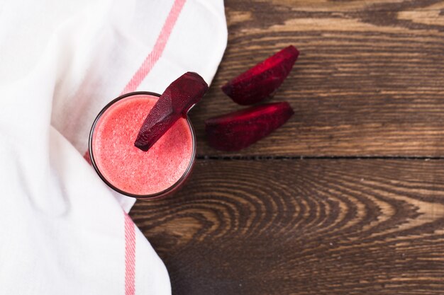 Beetroot juice in a glass on a wooden table