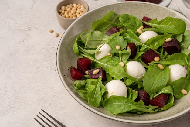 Beetroot mozzarella and arugula salad with pine nuts top view