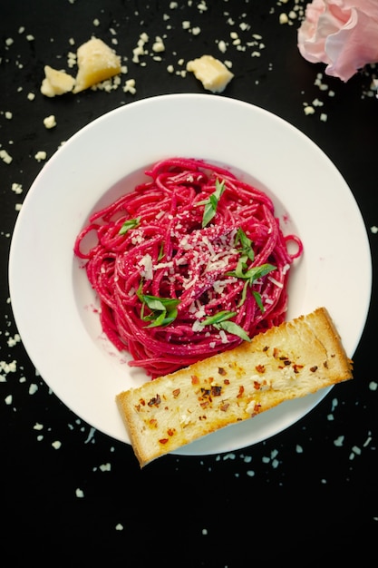 Foto pasta alle barbabietole con spezzatino all'aglio