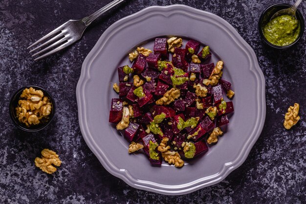 Photo beetroot, pesto sauce and walnut salad, top view