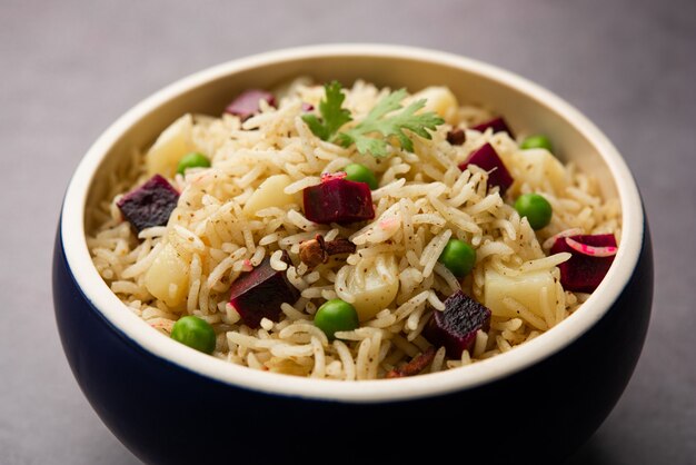 Beetroot Rice or pulao or pulav served in a bowl or karahi, selective focus. Indian food