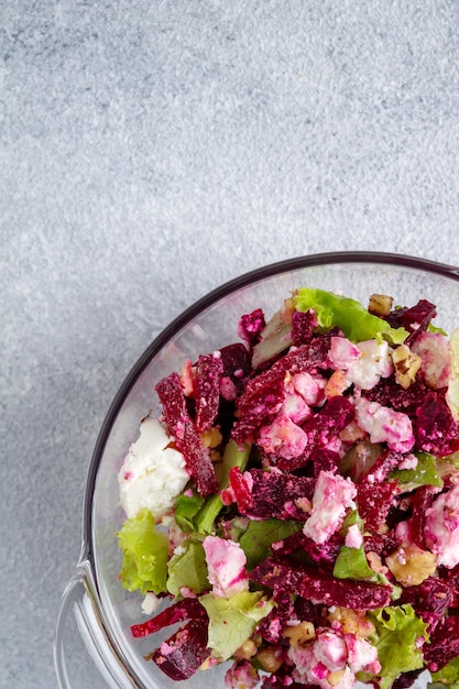 Beetroot salad green leaves cheese walnuts in a glass plate copy space