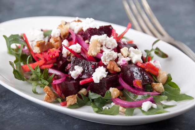 Beetroot salad with cheese and nuts in a white plate