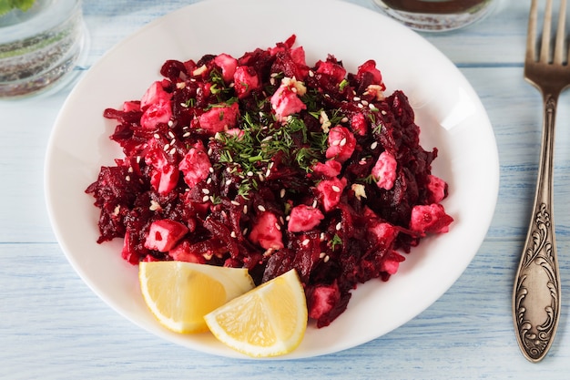 Beetroot salad with lemon and feta on white plate