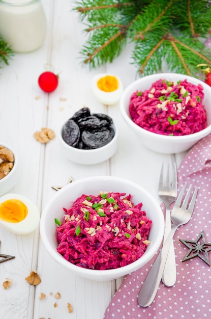 Beetroot salad with prunes, walnuts, eggs and sour cream in a bowl