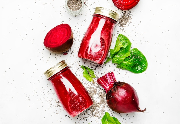 Beetroot smoothies with chia seeds glass bottles gray background top view