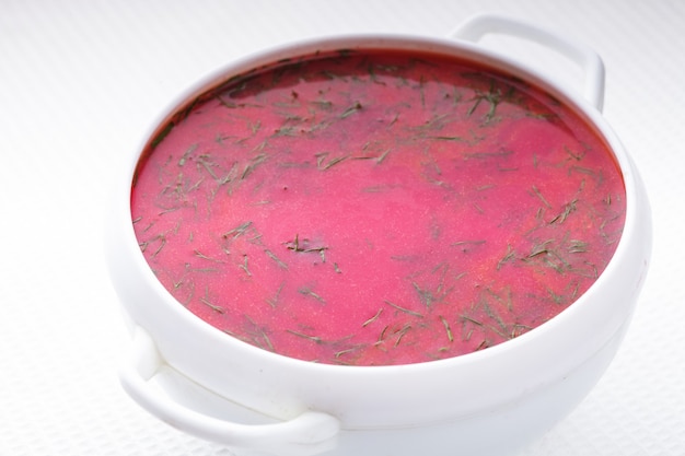 Beetroot soup in the white bowl close up