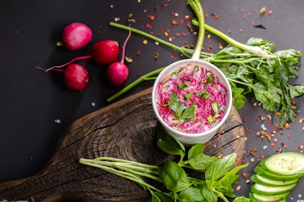 Beetroot soup with beets, fresh cucumbers, greens, in cardboard packaging, on a vintage board and