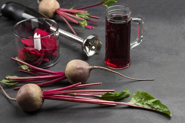 Beets with tops sliced beets Glass of beetroot juice Sliced beet in blender jar Cutter