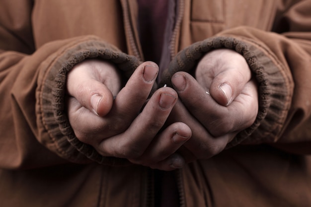 Foto concetto di mendicante. il povero chiede assistenza in contanti. monete d'argento nel primo piano delle palme