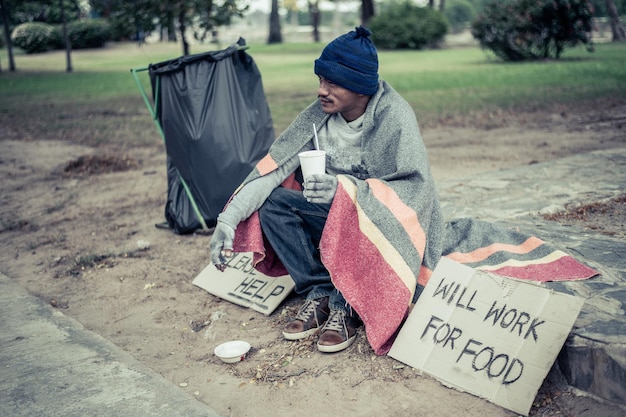 The beggars sat wrapped in cloths and eating noodles