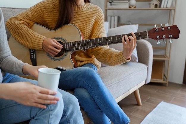 A beginner woman with best friend playing acoustic guitar\
lesson